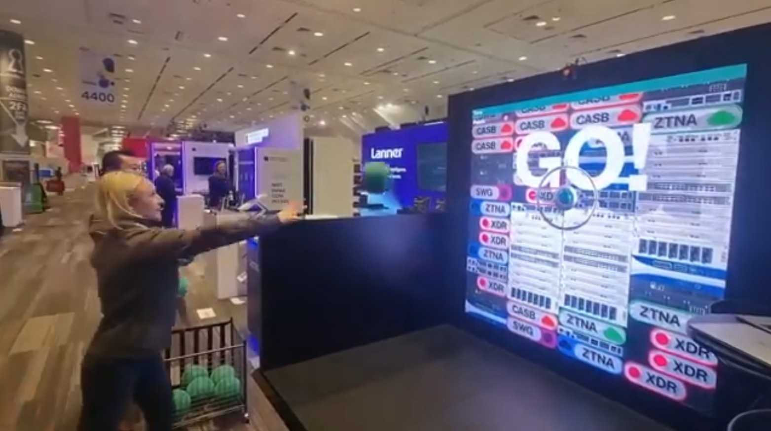 Visitor throwing a ball at an interactive LED wall game at the CATO Networks booth, RSA Conference